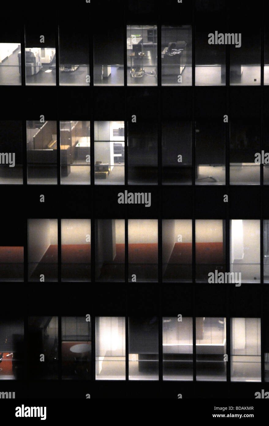 Exterior shot of an office building at night with the lights on in different floors Stock Photo