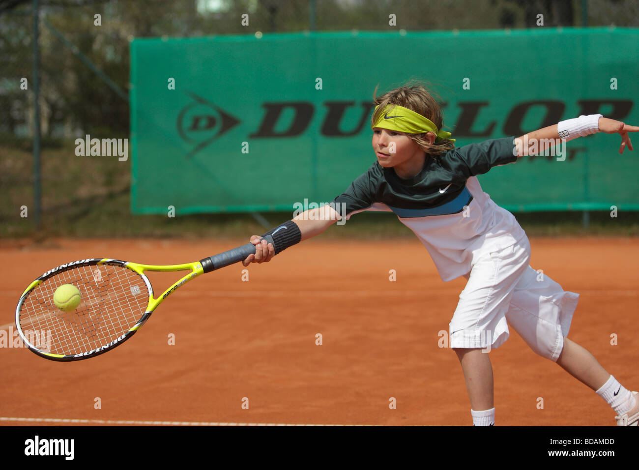 Little boy stretching for a forehand volley at a tennis camp Stock Photo -  Alamy