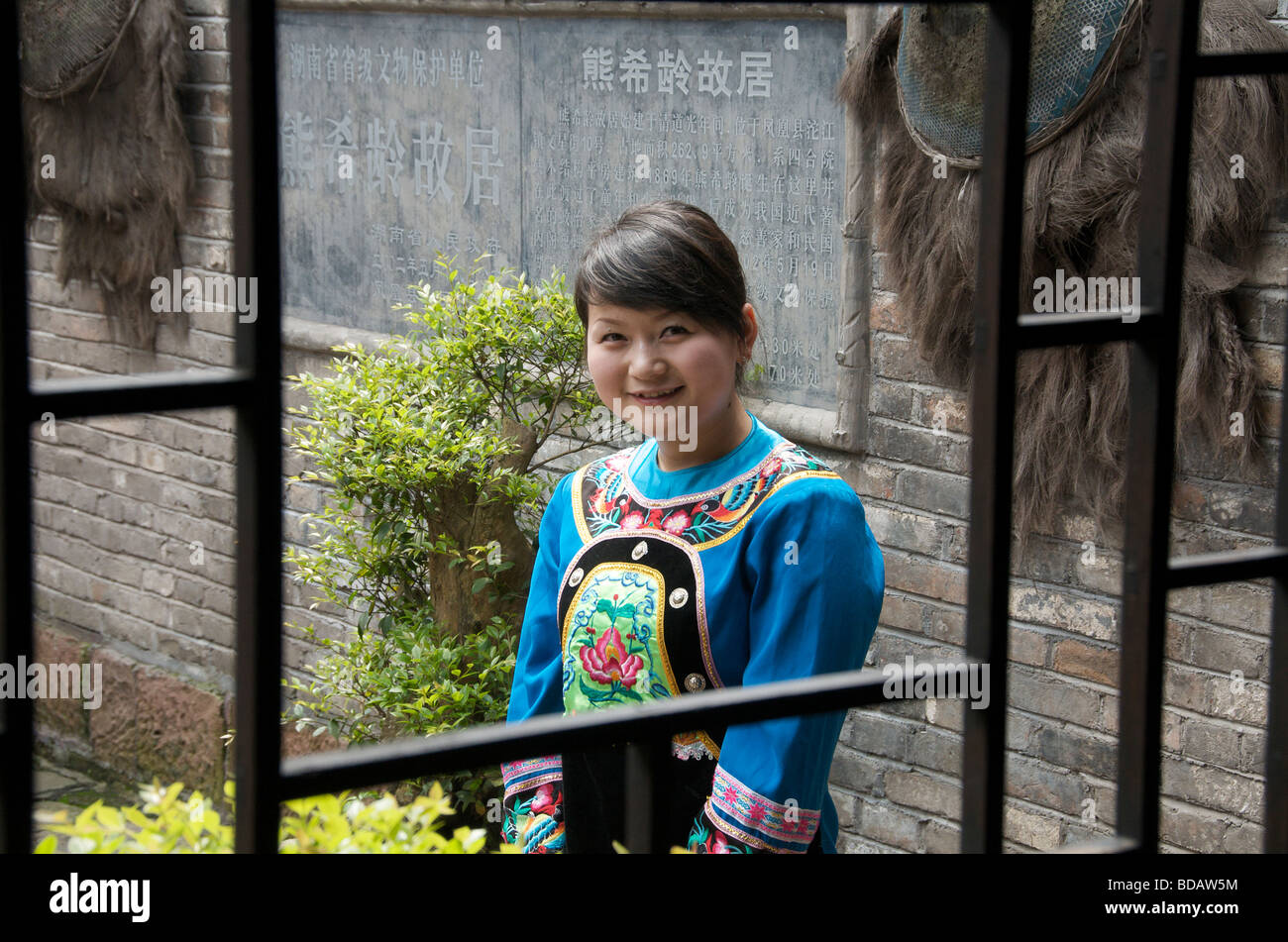 Pretty smiling guide framed in window Ancient Town of Fenghuang Hunan China Stock Photo