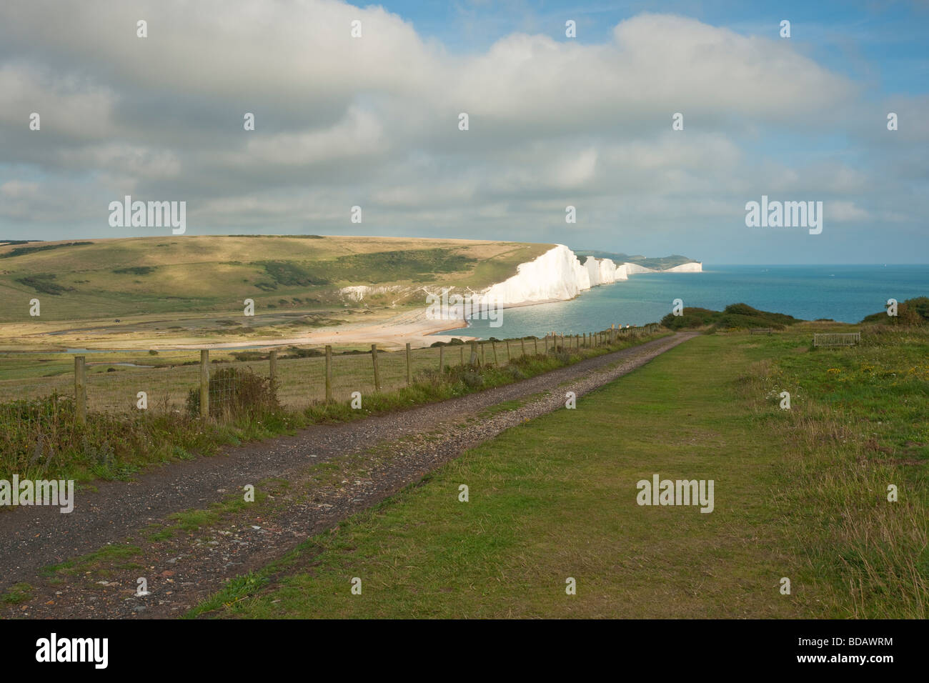 View of Seven Sisters chalk cliffs from Seaford Head with leading path Stock Photo