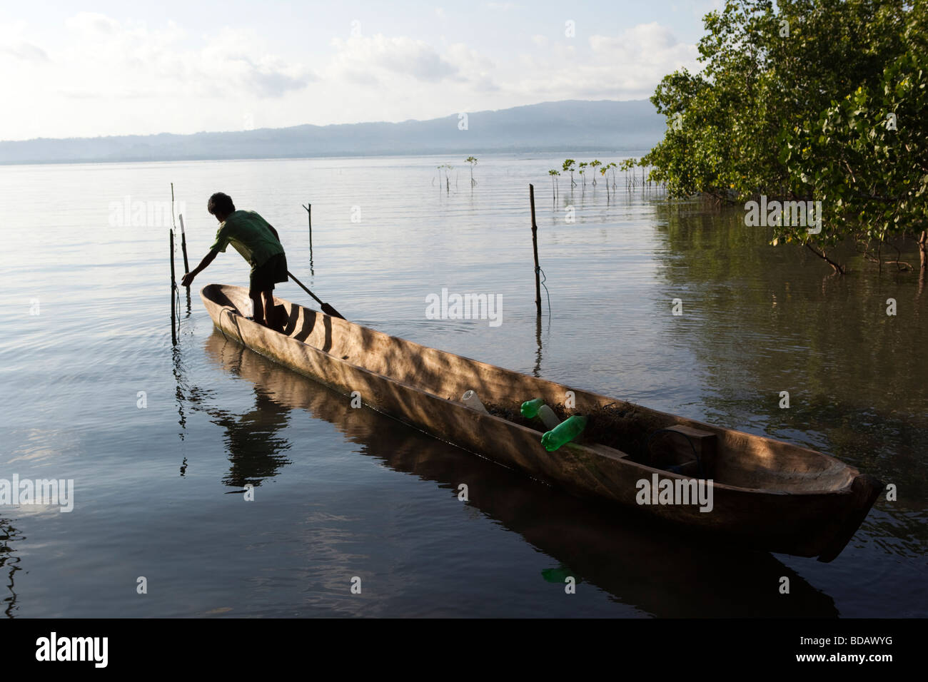 Indonesia Sulawesi Buton Labundo Bundo coastal seaweed farm man in dugout canoe Stock Photo