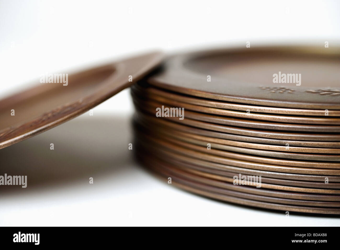 Closeup of a stack of bronze plates Stock Photo Alamy