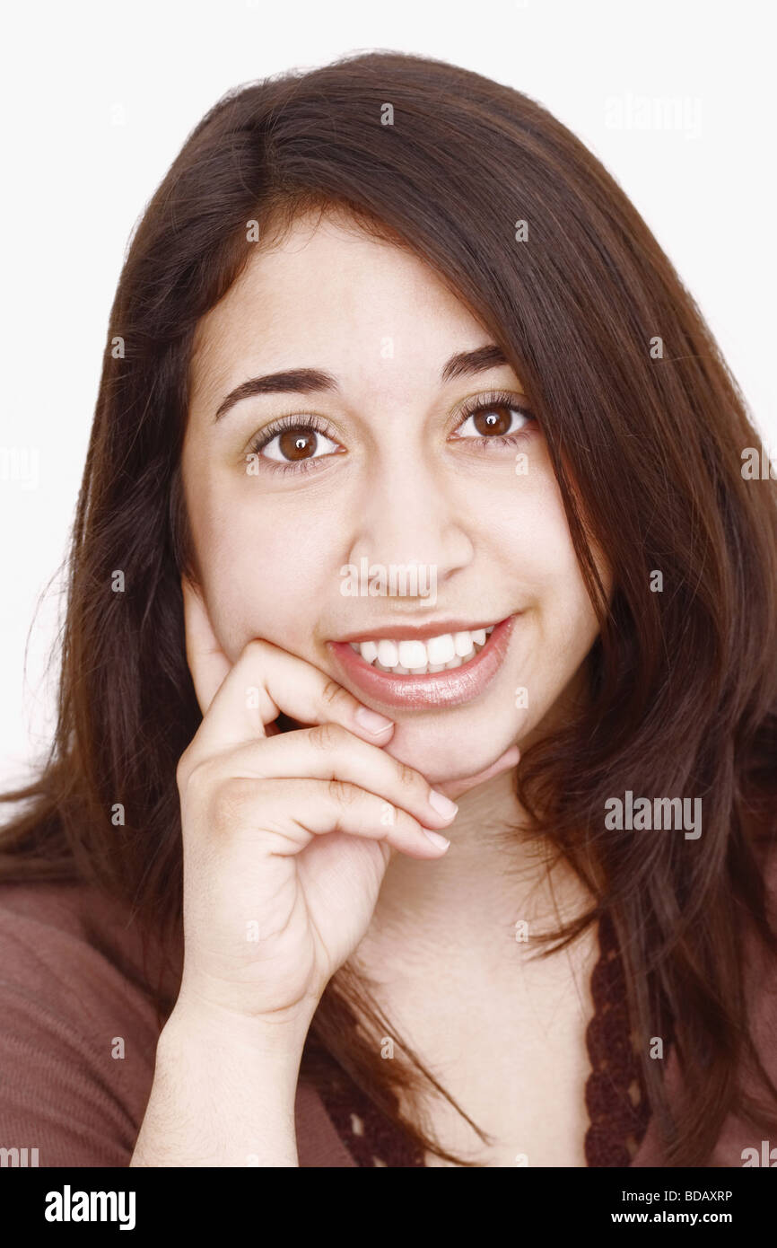 Portrait of a young woman smiling with her hand on her chin Stock Photo ...