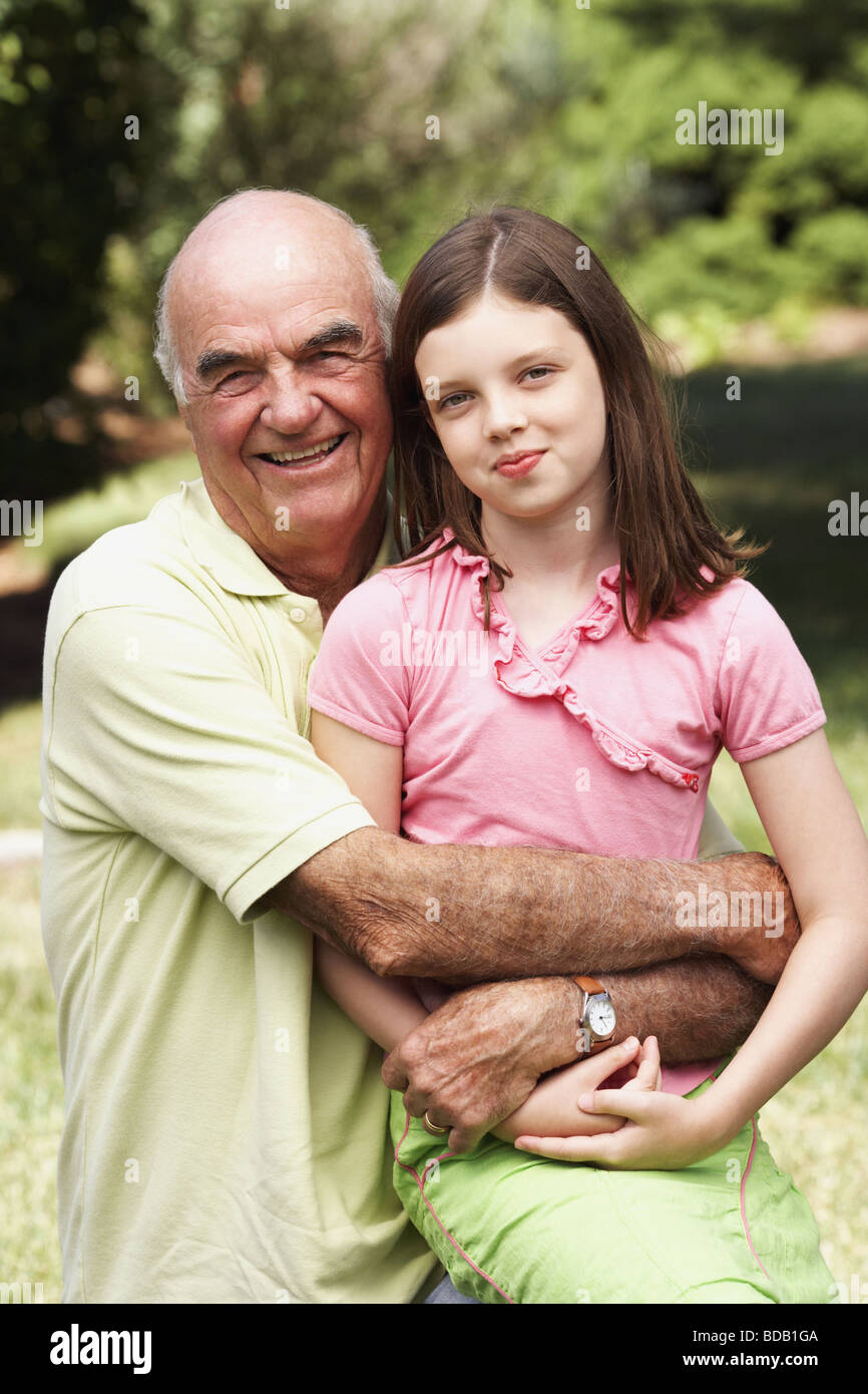 Senior man smiling in a park with his granddaughter Stock Photo