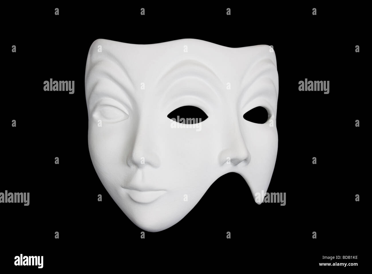 Double face white mask isolated over black background. Stock Photo