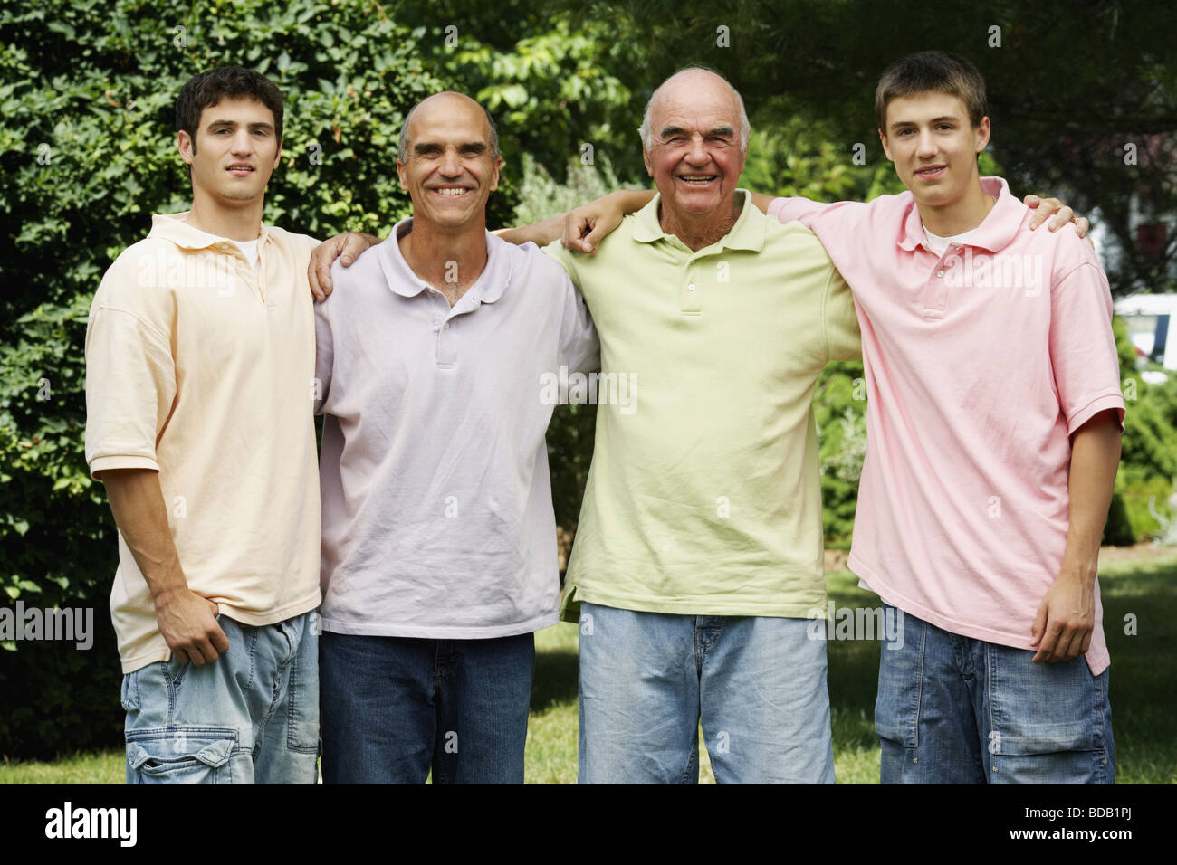 Senior man standing with his son and grandsons in a park Stock Photo