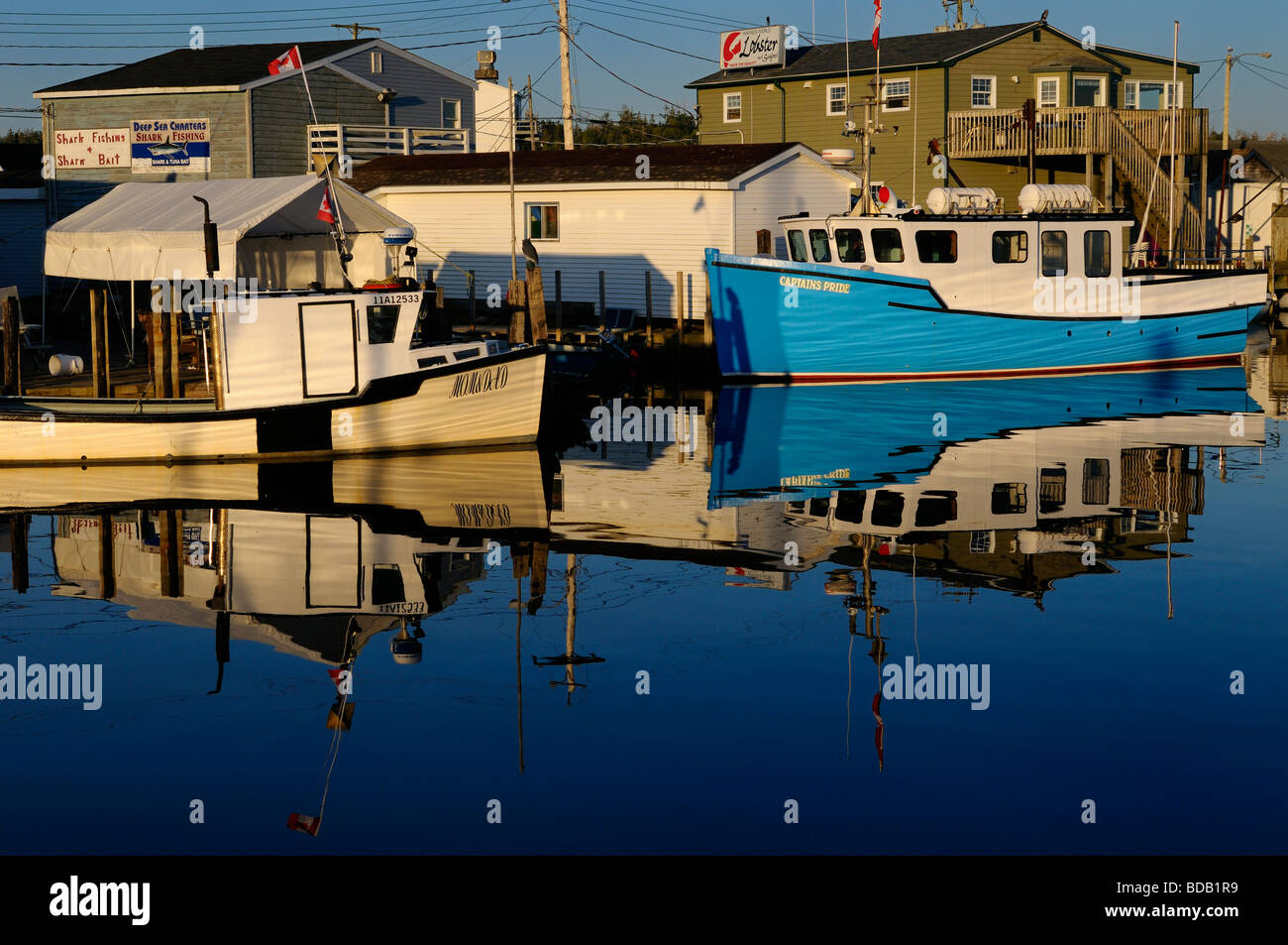 Deep sea shark charter boats on calm morning water on blue sky day at