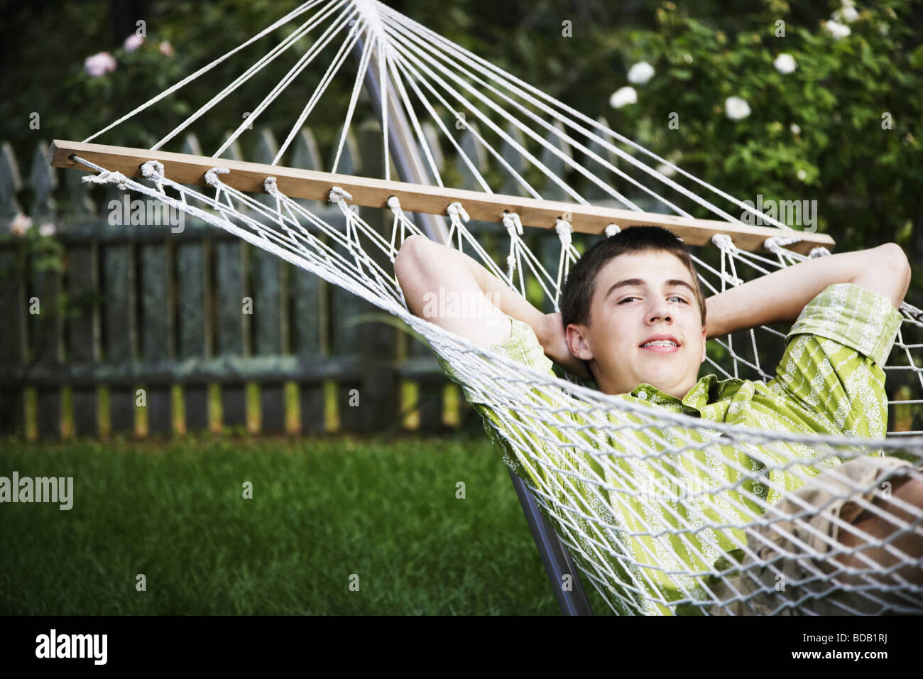 Portrait of a teenage boy lying in a hammock with his hands behind his head Stock Photo