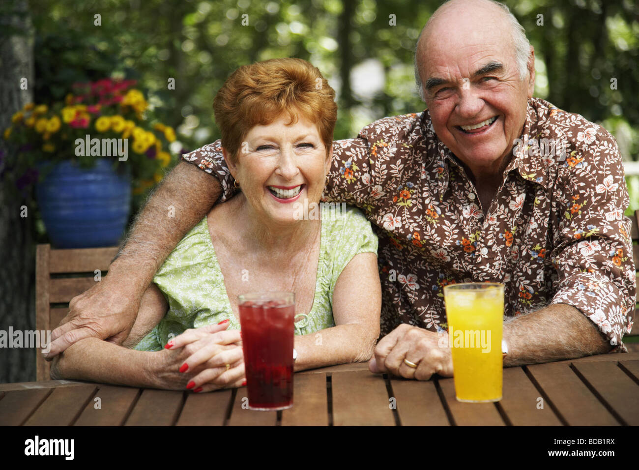 Portrait of a senior couple sitting at a table and smiling Stock Photo