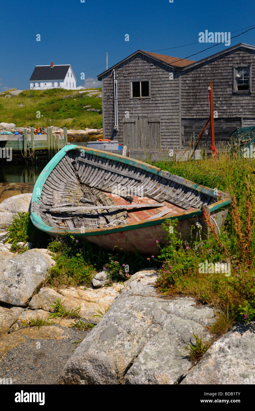 Houses and abandoned fishing boat on the rocks in full sun at Peggy's Cove Nova Scotia Stock Photo
