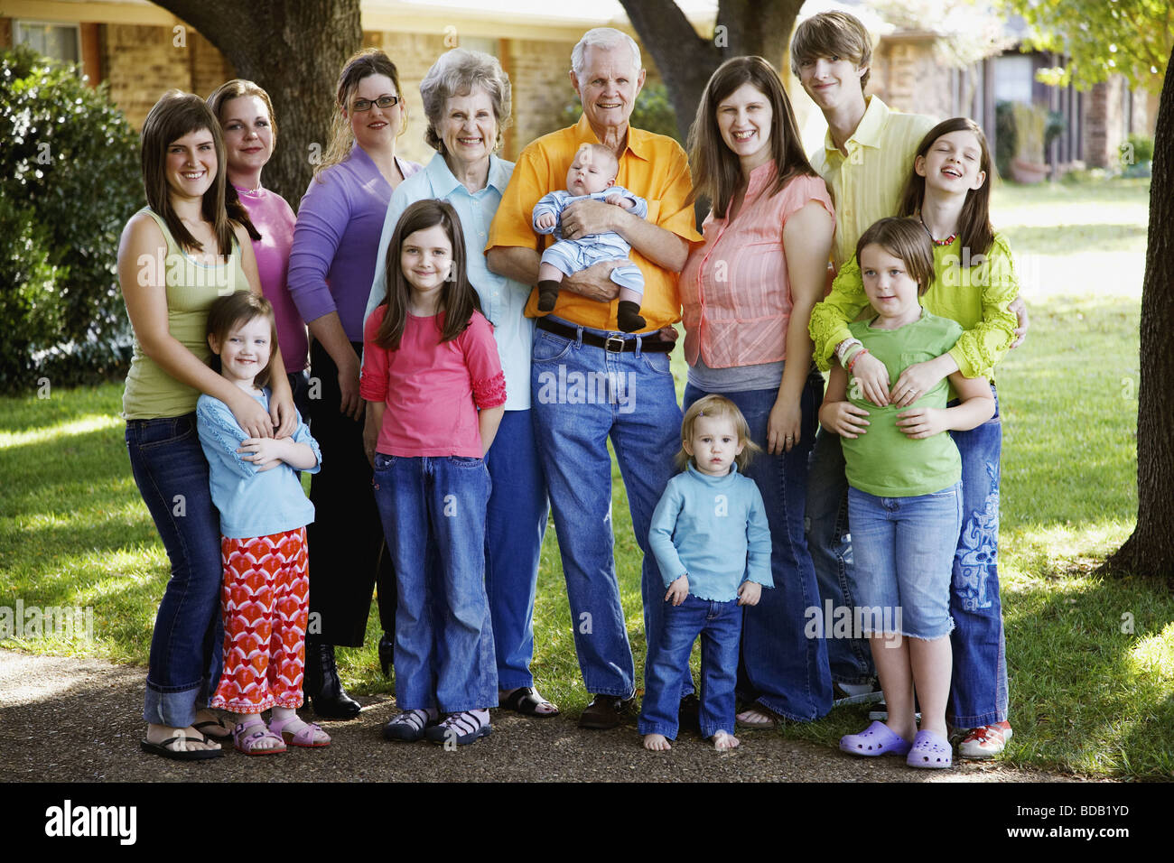 Portrait of a family standing together in a garden Stock Photo - Alamy