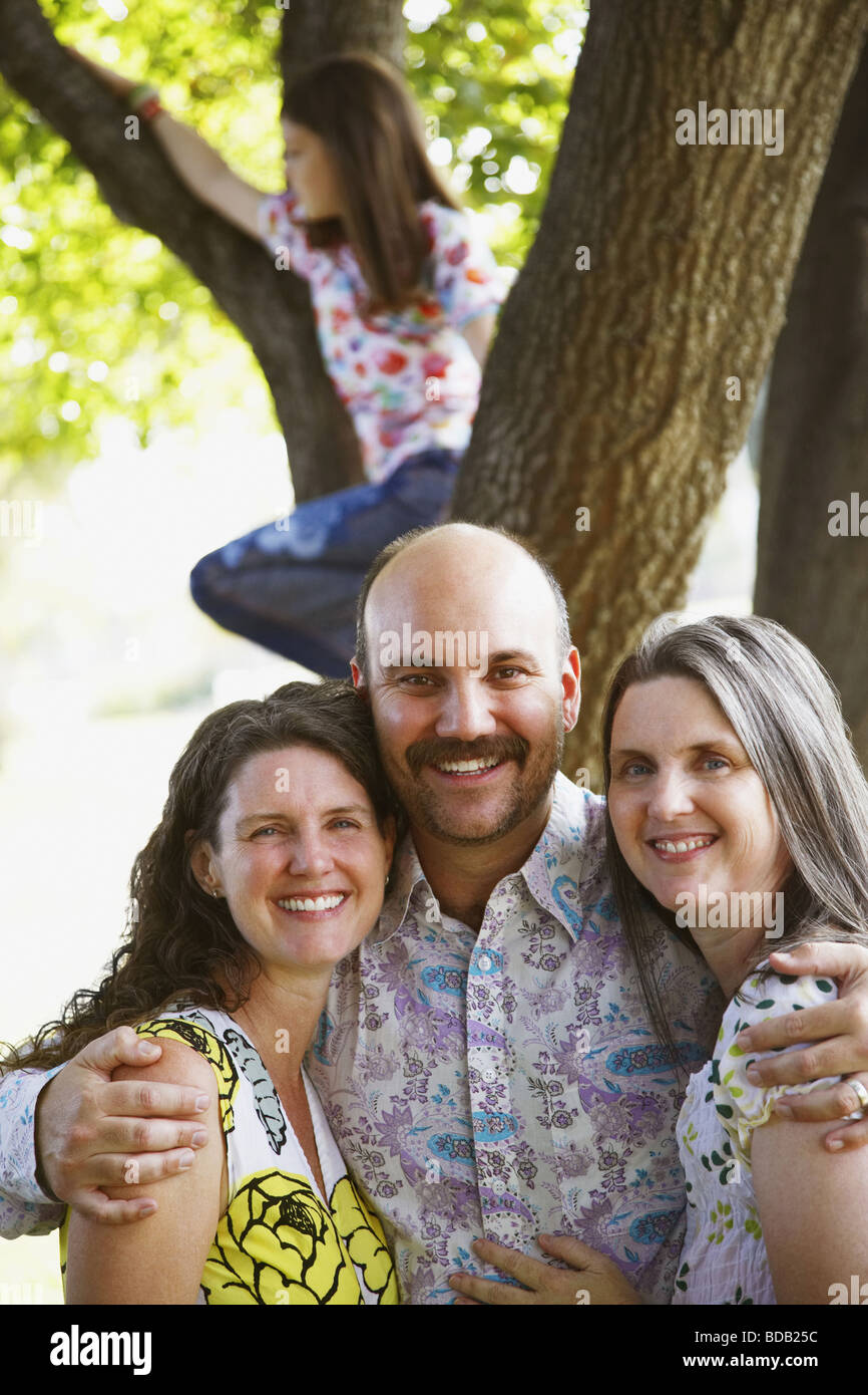 Portrait of a mid adult man arm around two mature women and smiling Stock Photo