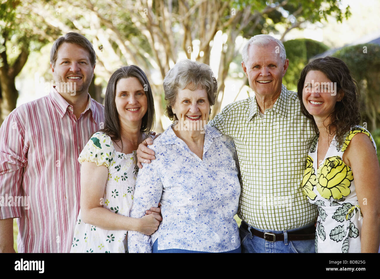 Portrait of a senior couple standing with their daughters and a mature man Stock Photo