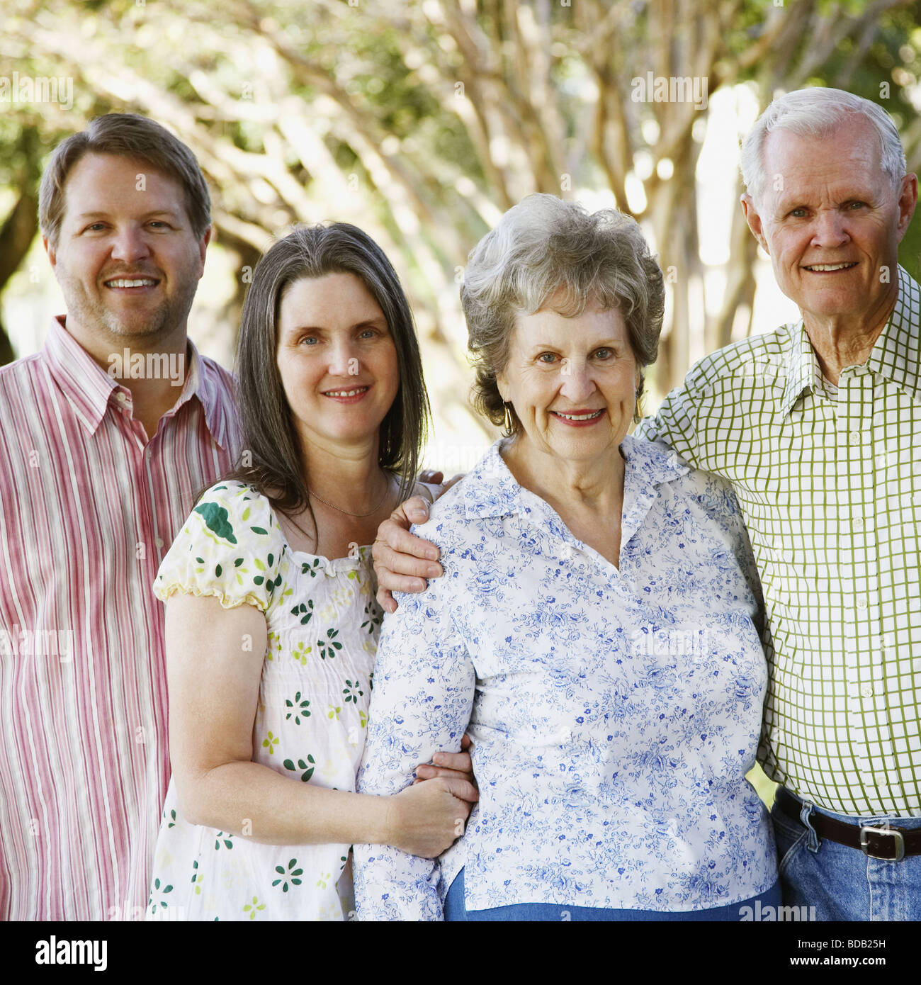 Portrait of a senior couple standing with their daughters and a mature man Stock Photo