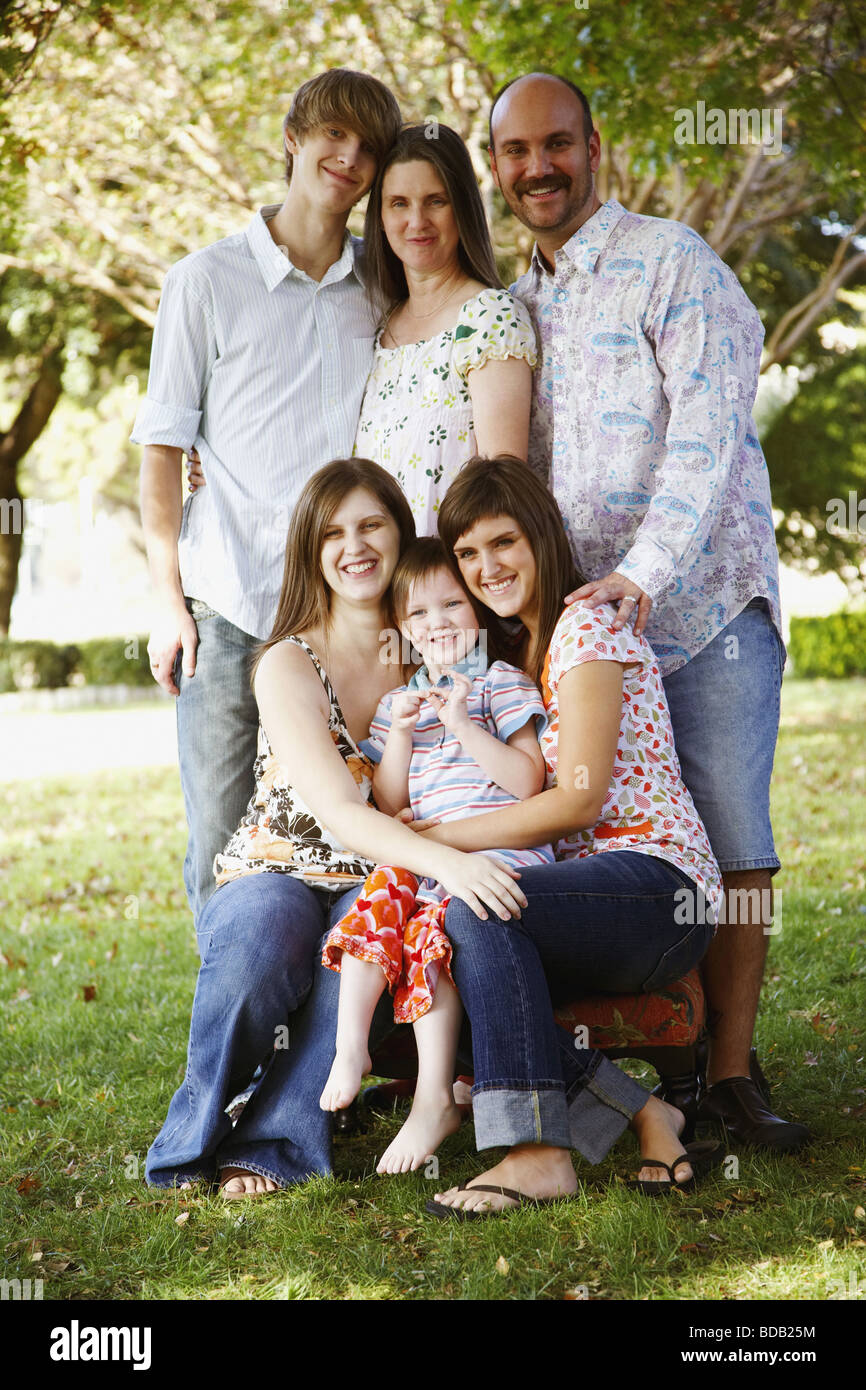 Portrait of a couple with their son and daughters in a lawn Stock Photo