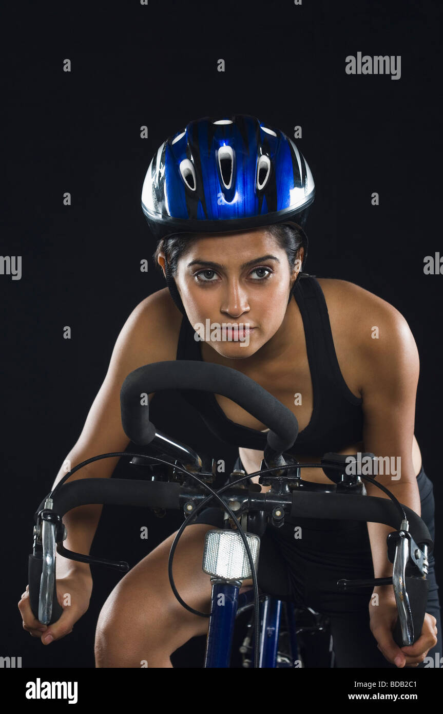Portrait of a young woman wearing a cycling helmet and riding a bicycle Stock Photo