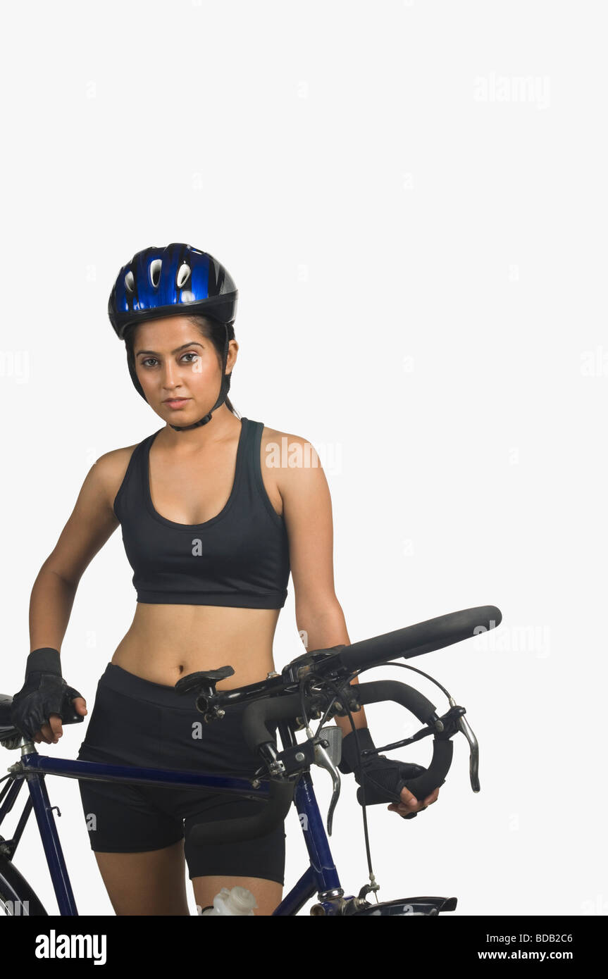 Portrait of a young woman wearing a cycling helmet and holding a bicycle Stock Photo