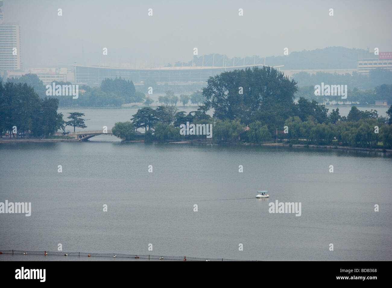 Paddle boat on Xuanwu Lake and Nanjing Station in the haze of polluted air, Nanjing China Stock Photo