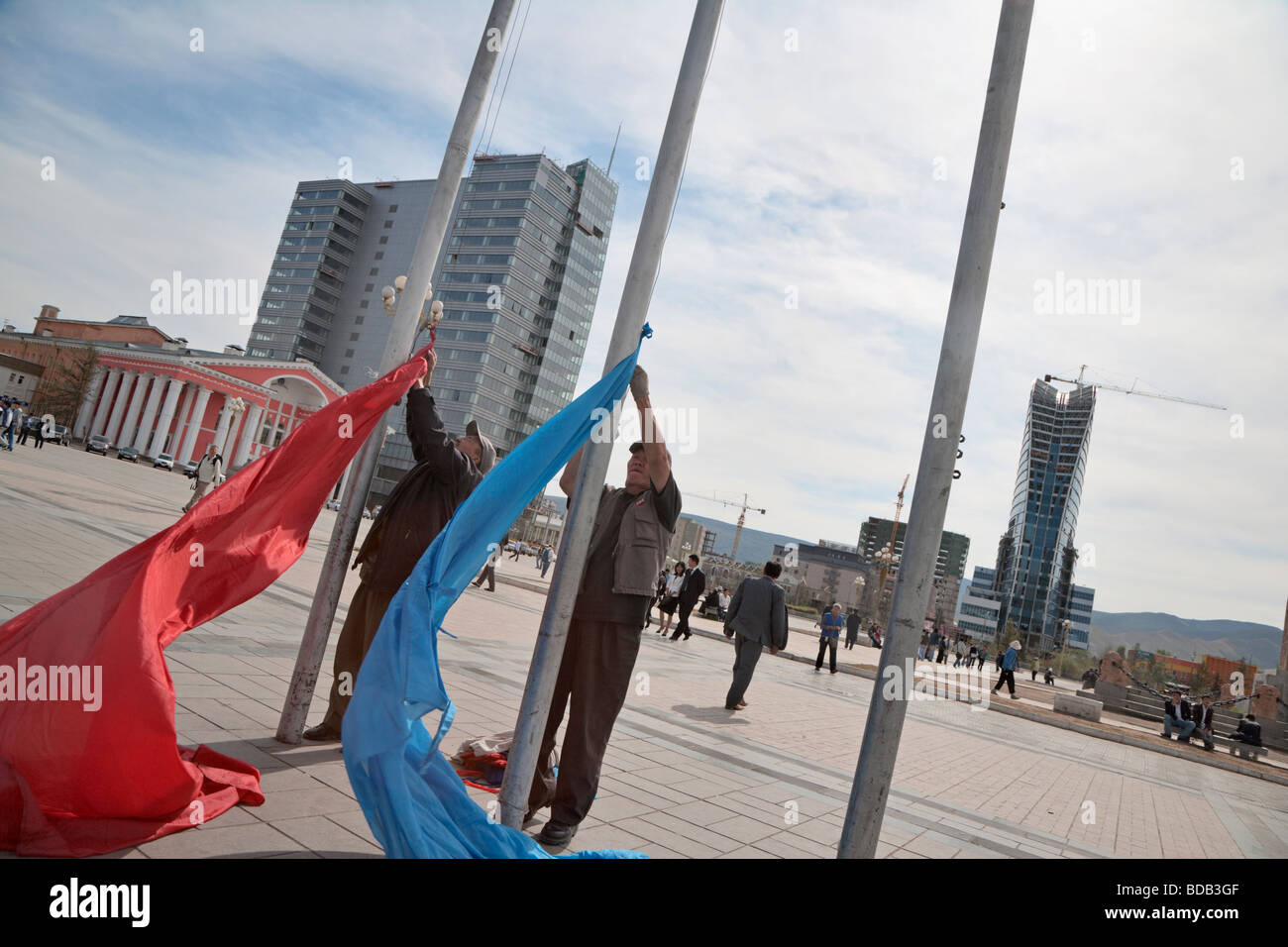 Mongolian men raise flags for a ceremony at Sukhbaatar Square, Ulaan Baatar, Mongolia Stock Photo