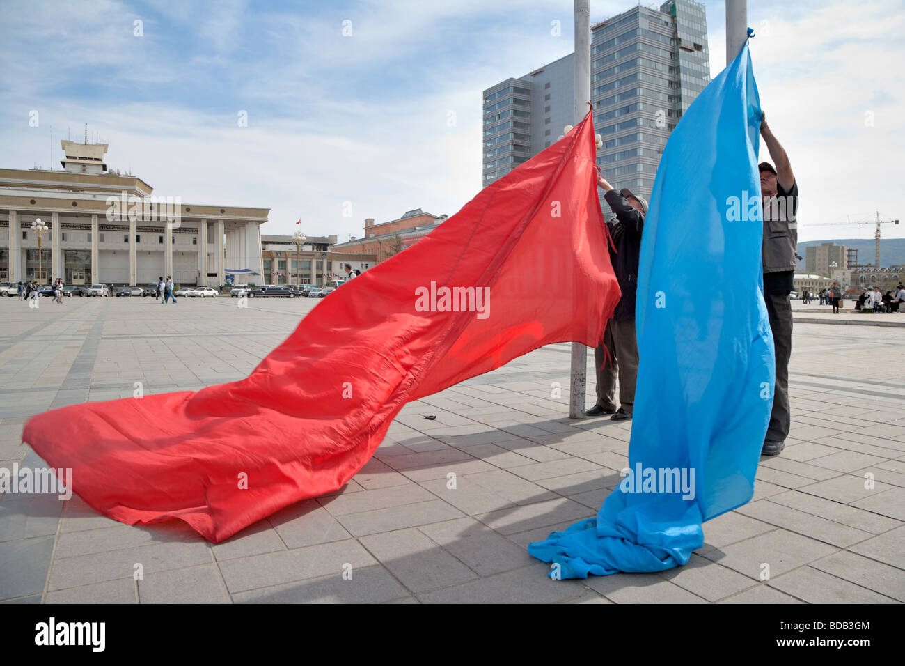 Mongolian men raise flags for a ceremony at Sukhbaatar Square, Ulaan Baatar, Mongolia Stock Photo