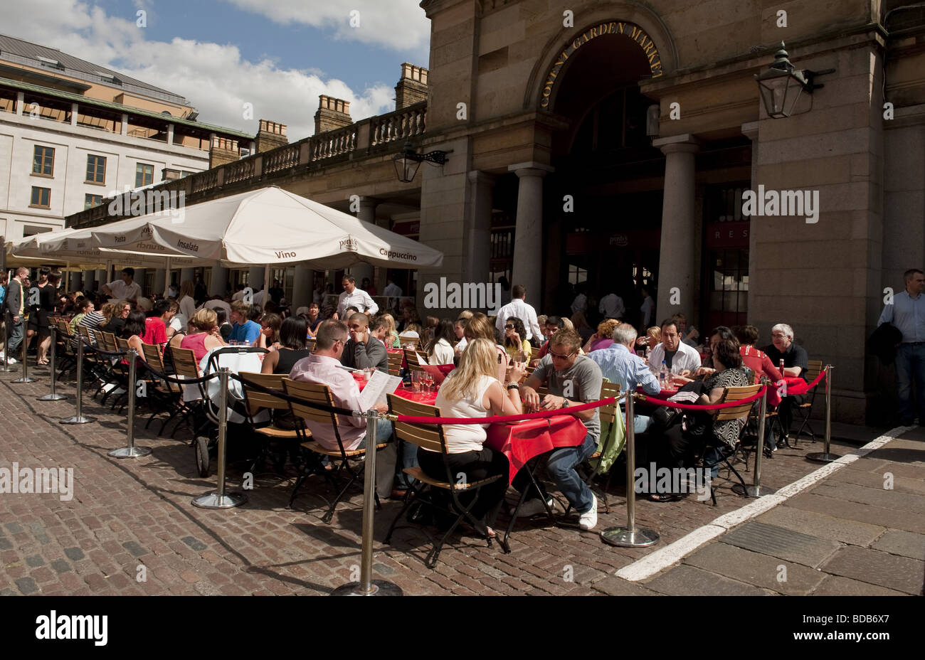 Large group of diners eating al fresco style in restaurant outside Covent Garden Market in West End of London Stock Photo