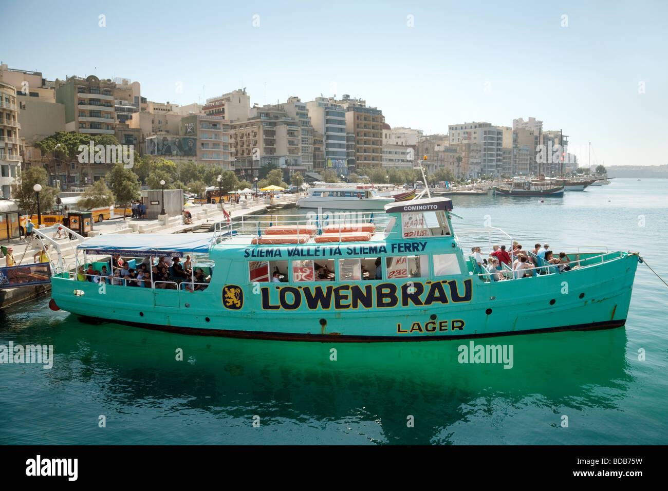 The Sliema to Valletta ferry, Malta with prominent Lowenbrau advertising Stock Photo