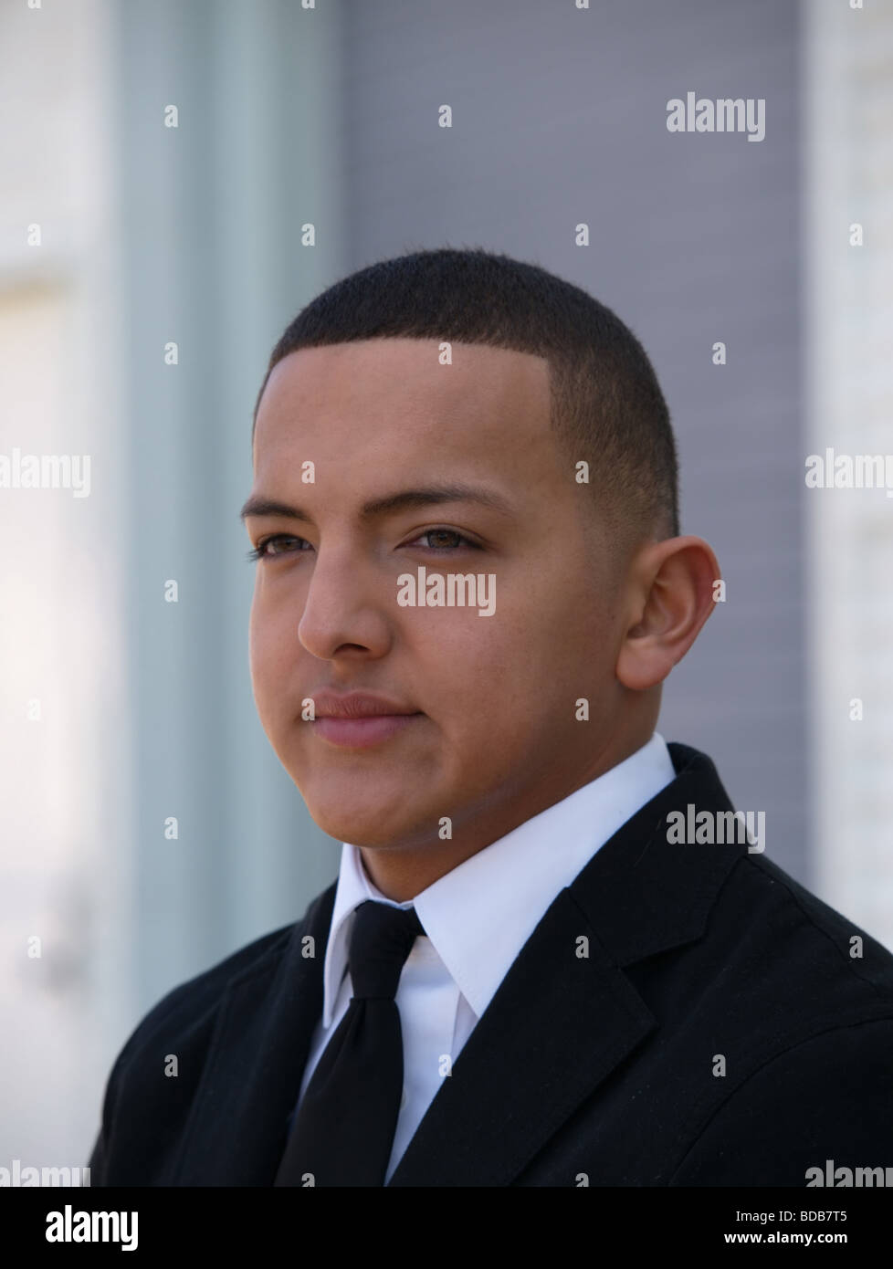 Hispanic young man with short hair and in a black business suit. Stock Photo