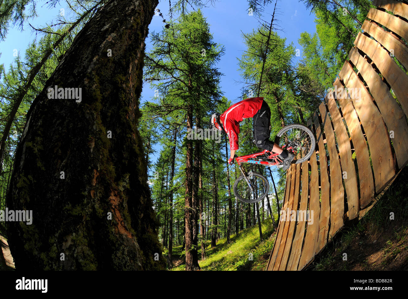 A mountain biker rides rides a wooden wall ride in Sauze D'oulx in the Italian Alps Stock Photo