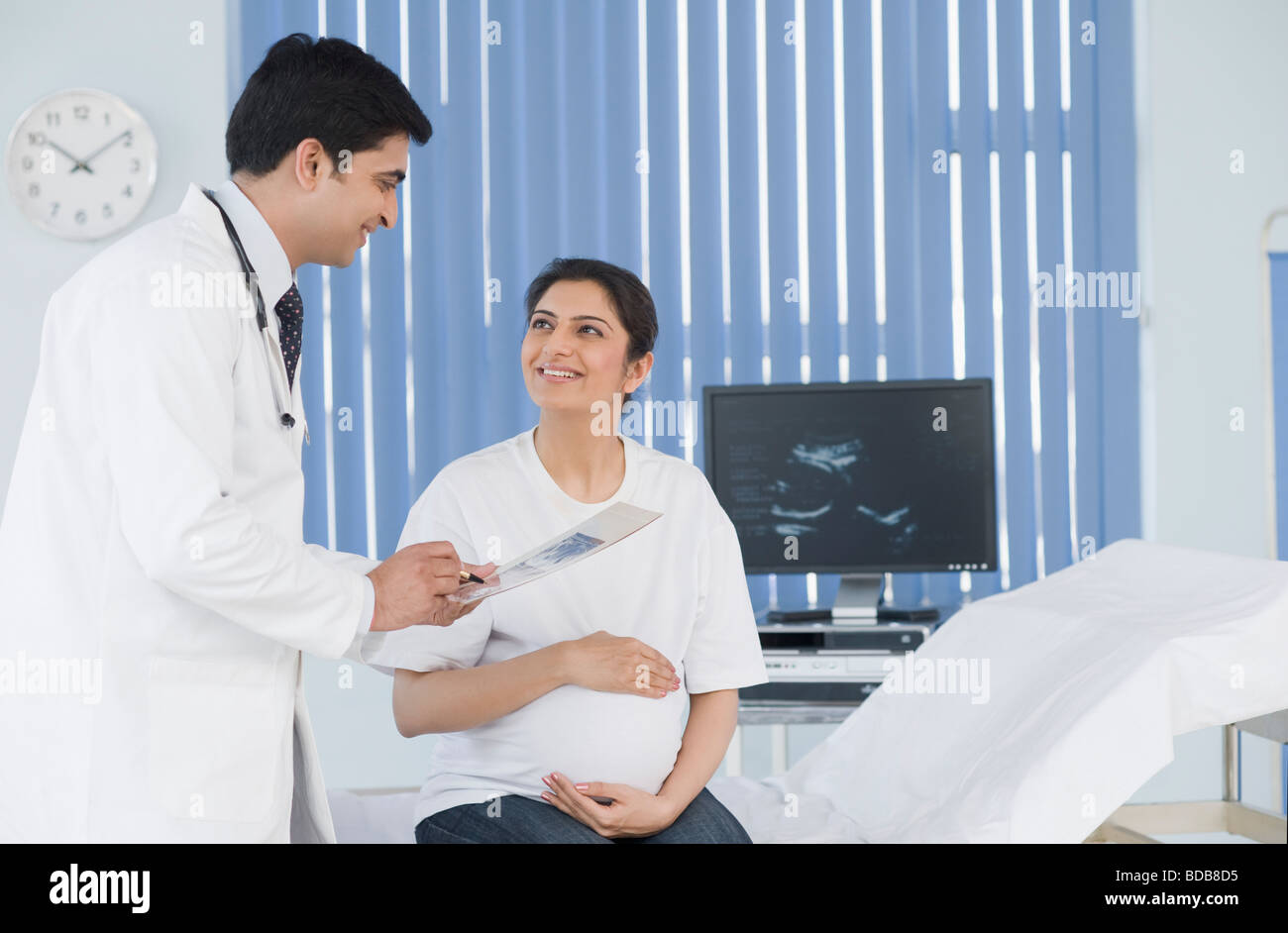 Male doctor showing ultrasound to pregnant woman Stock Photo - Alamy