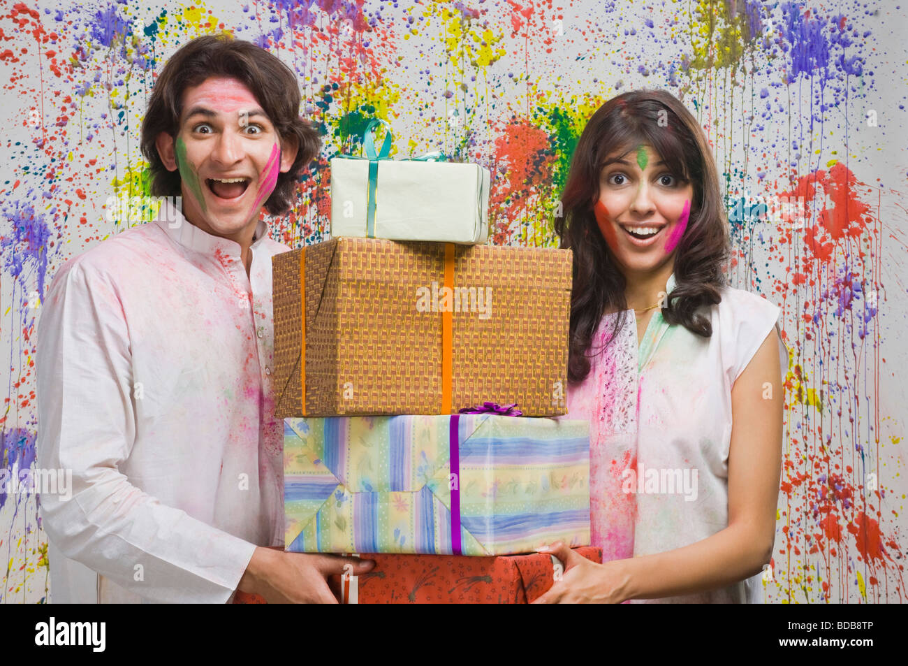 Couple holding gift boxes and smiling Stock Photo - Alamy
