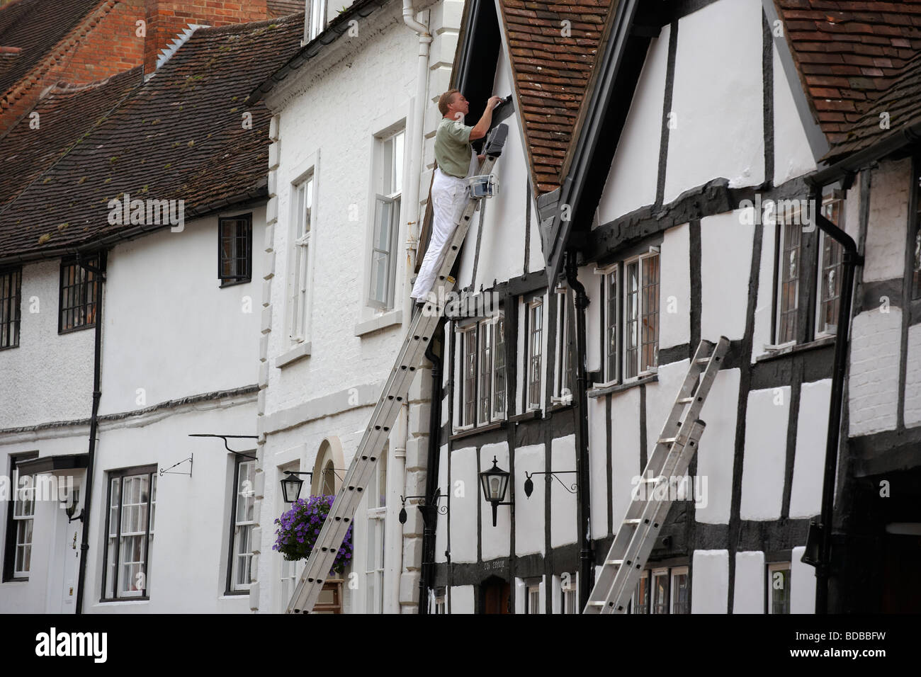 A painter at work on a house in Mill Street in Warwick UK Stock Photo