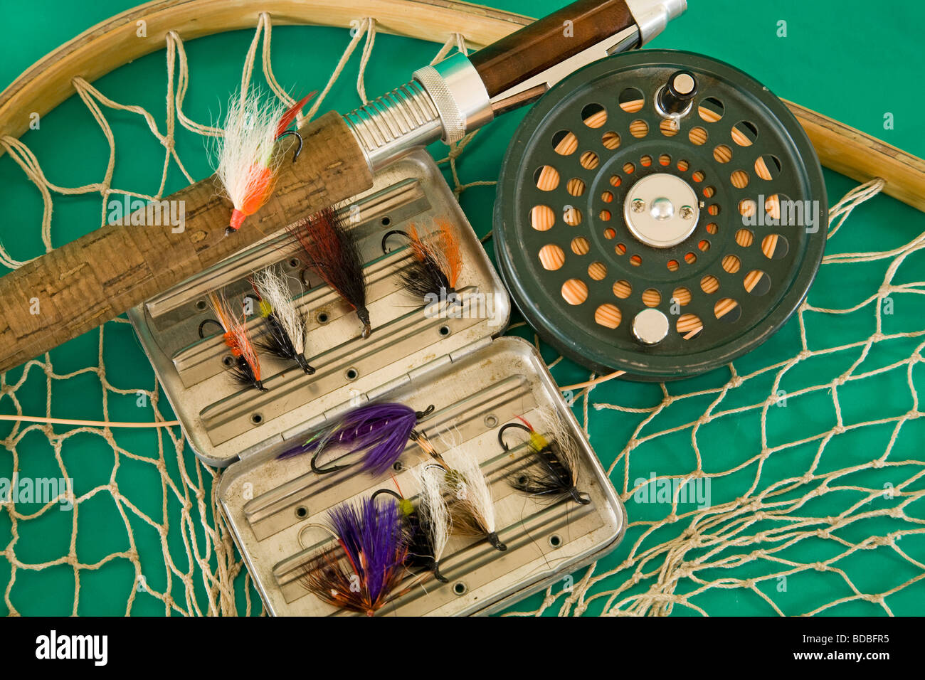 A fly rod, fly reel, trout fishing net, and box of artificial