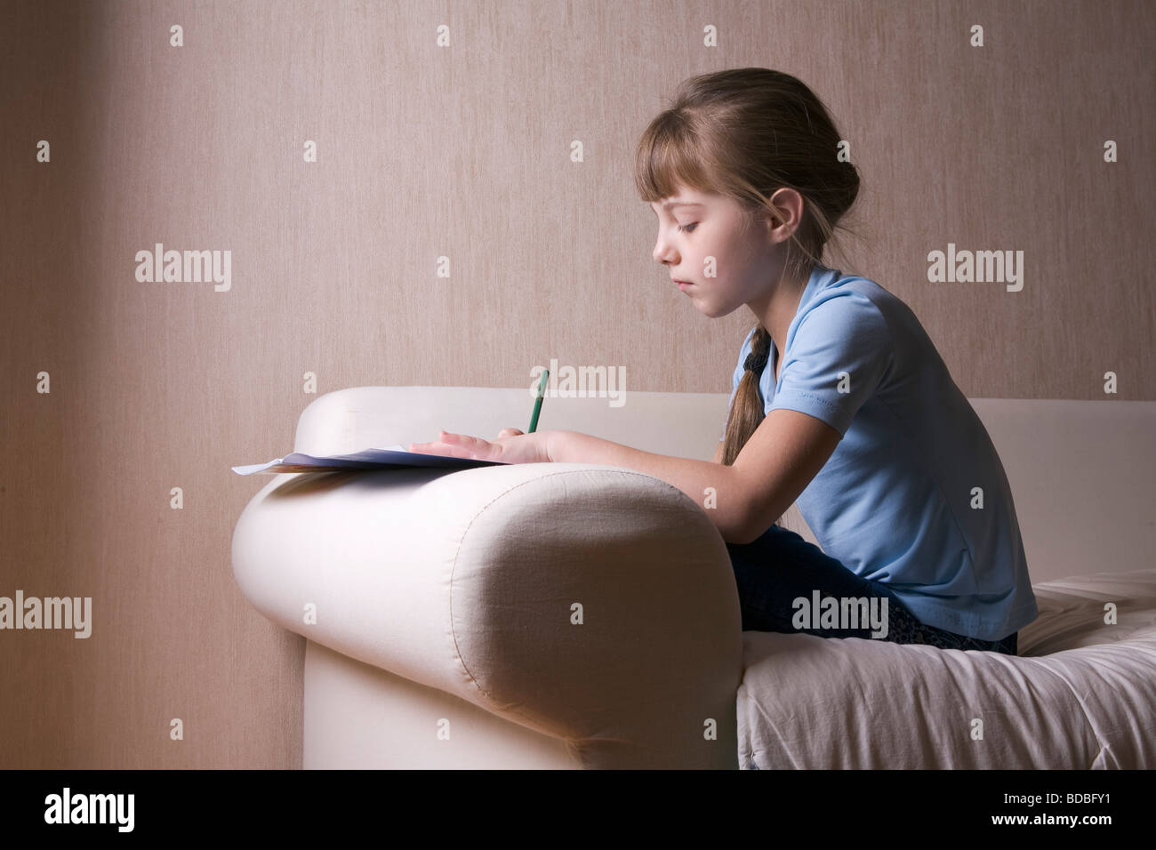 portrait of young girl sitting on sofa and drawing on paper Stock Photo ...