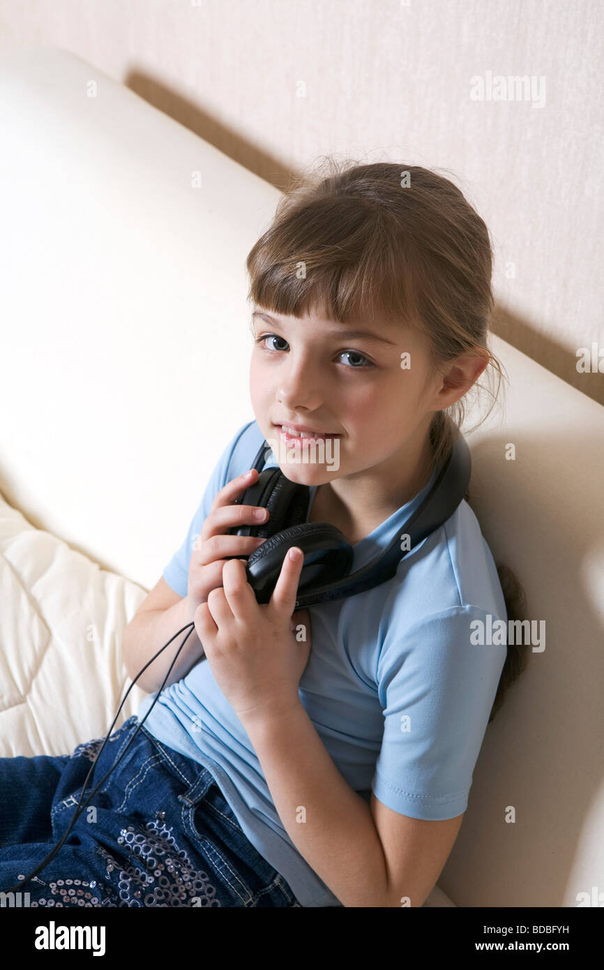 portrait of young girl sitting on sofa with earphones Stock Photo - Alamy