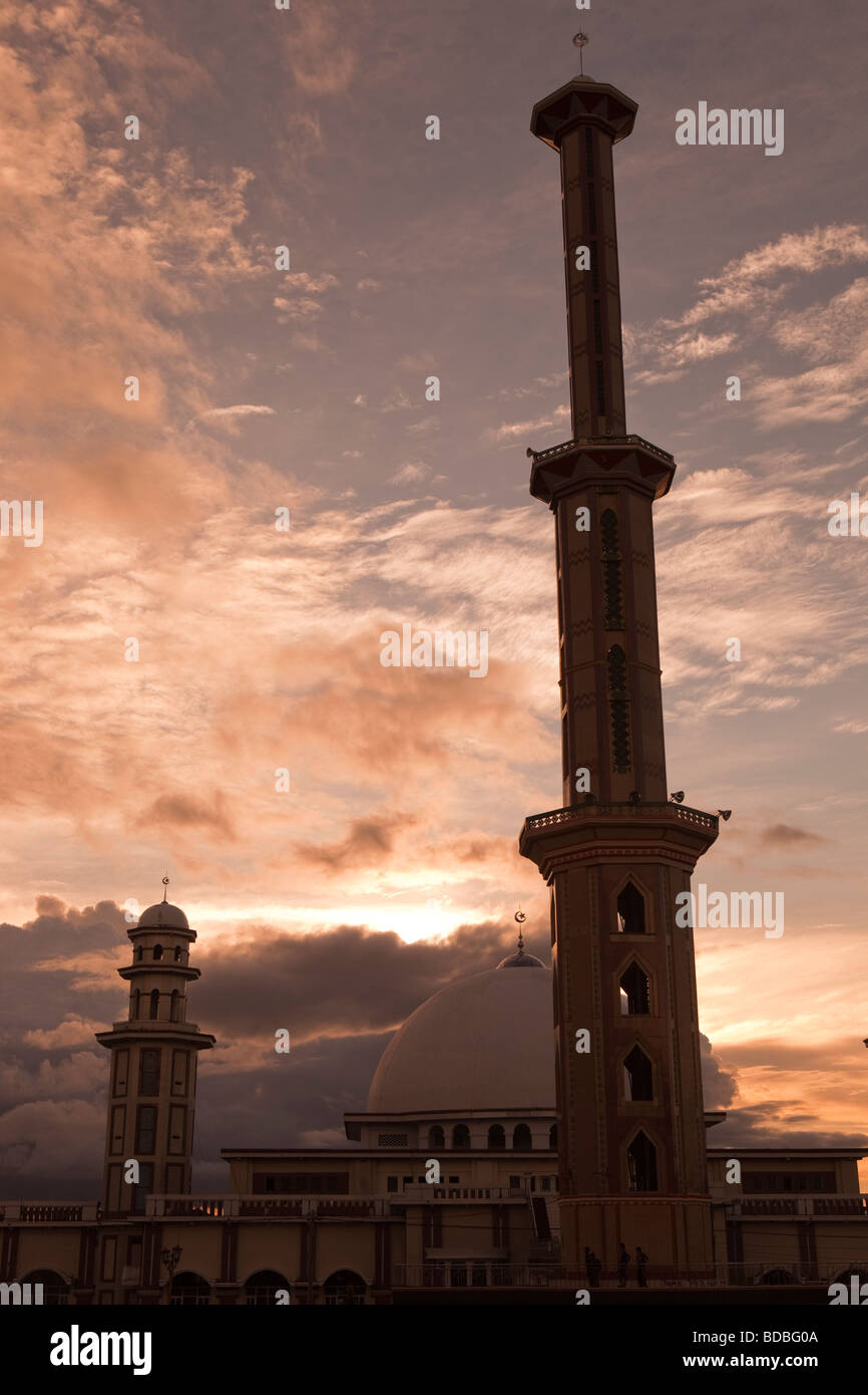 Indonesia Sulawesi Sengkang tall minaret of main mosque high above town skyline at sunset Stock Photo