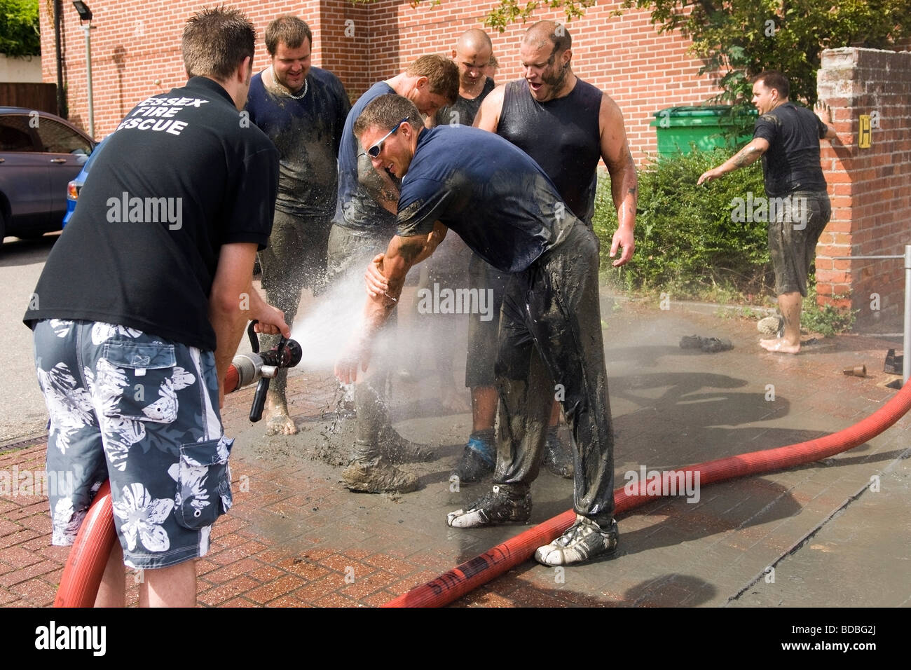 Off-duty fireman hosing down tug-of-war competitors Stock Photo