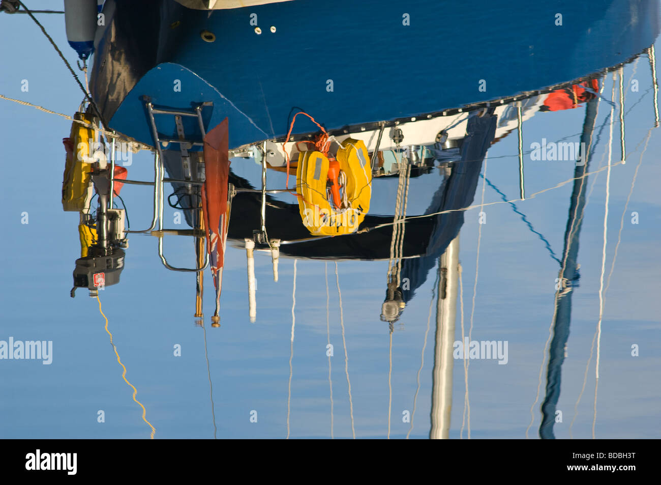 Reflection in a still lake of the rigging of a sailing boat. Stock Photo