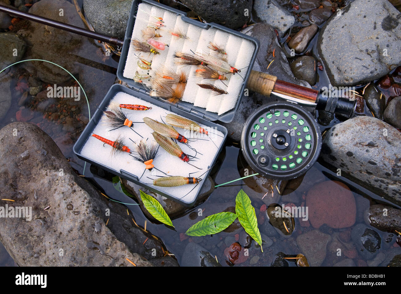 A fly rod, fly reel, trout fishing net, and box of artificial flies