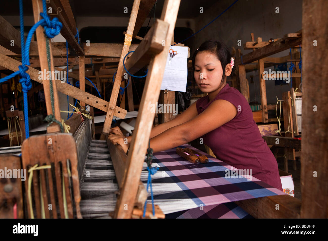 Indonesia Sulawesi Sengkang young women hand weaving silk cloth in small local workshop Stock Photo