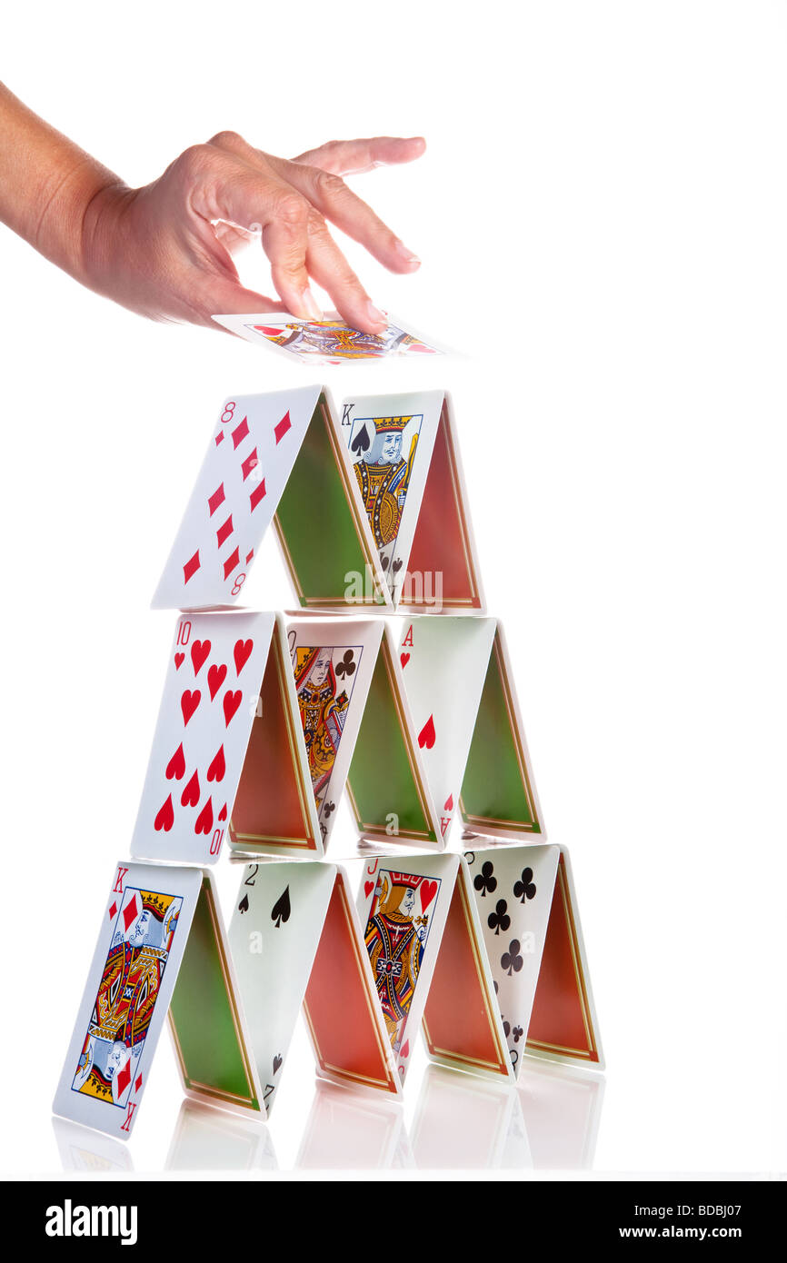 Hand trying to build a house of cards Stock Photo