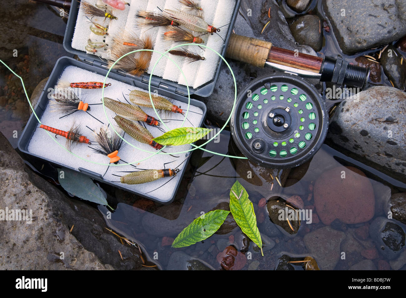 A fly rod, fly reel, trout fishing net, and box of artificial flies