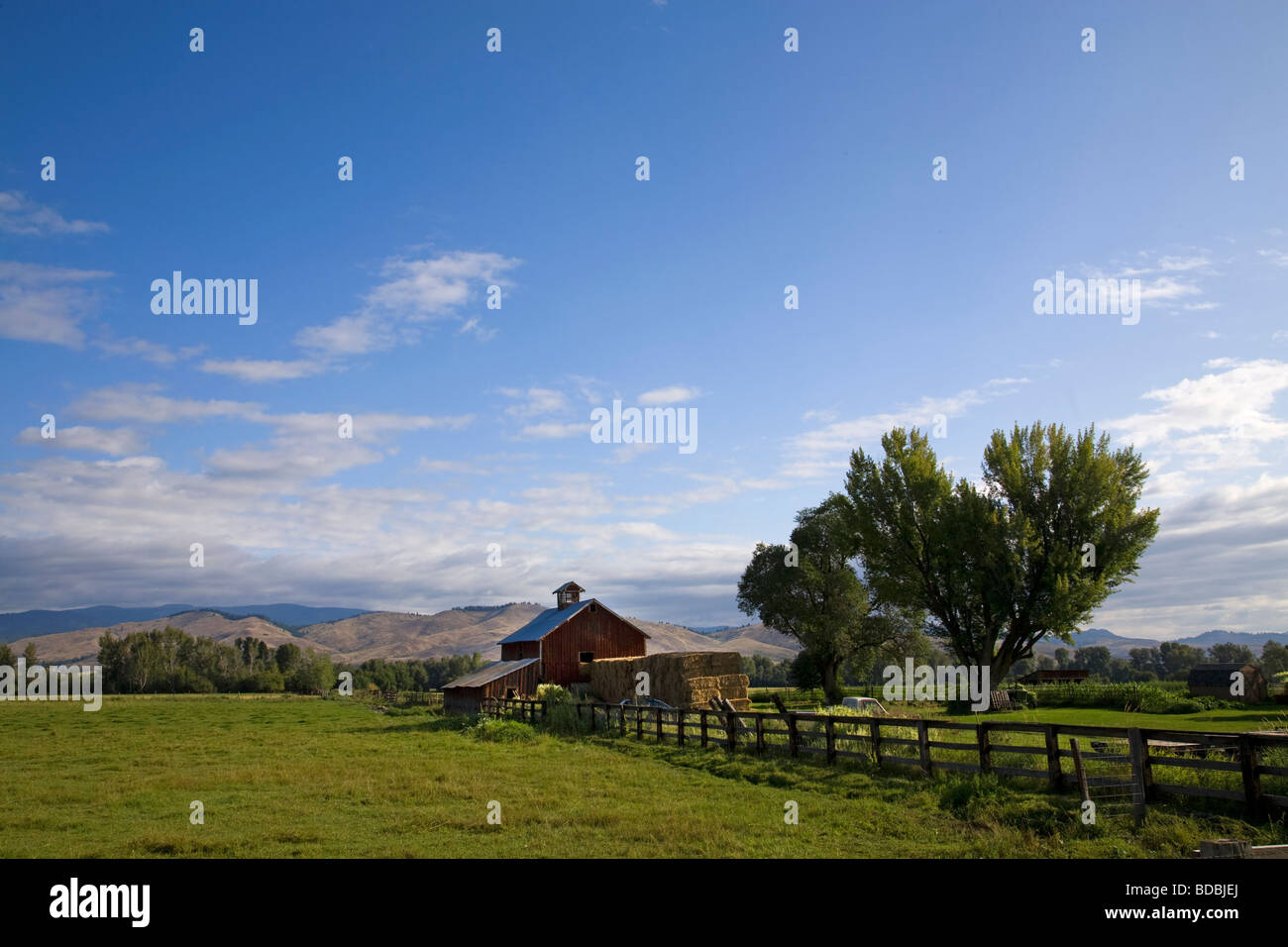 An old red barn and haystack on a ranch near Halfway Oregon on the slopes of the Wallowa Mountains in eastern Oregon Stock Photo