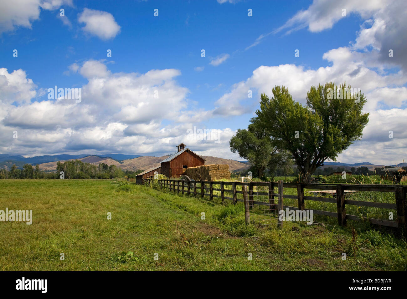 An old red barn and haystack on a ranch near Halfway Oregon on the slopes of the Wallowa Mountains in eastern Oregon Stock Photo