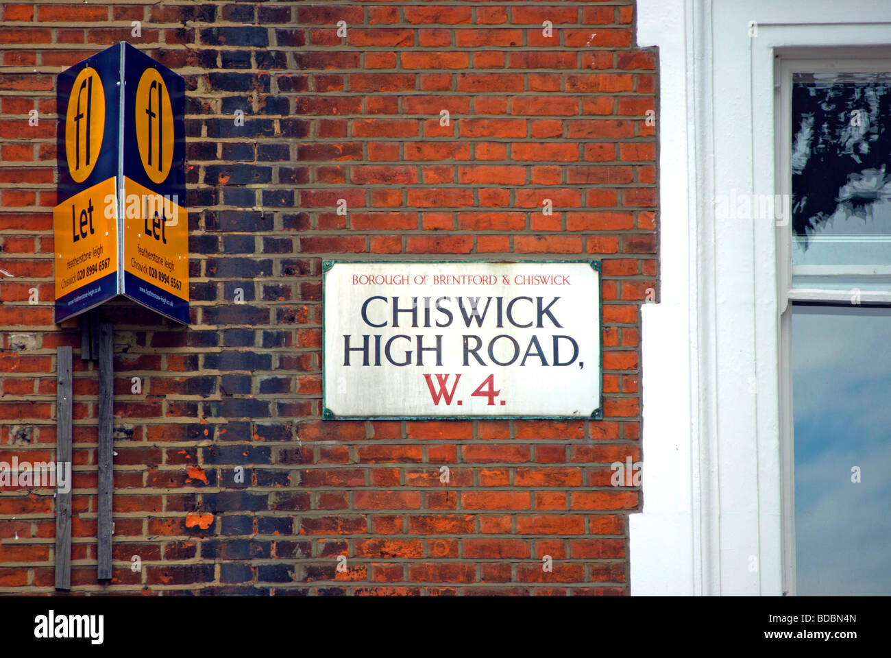 street name sign for chiswick high road, london w4, in chiswick, west london, england, beside estate agent's let sign Stock Photo