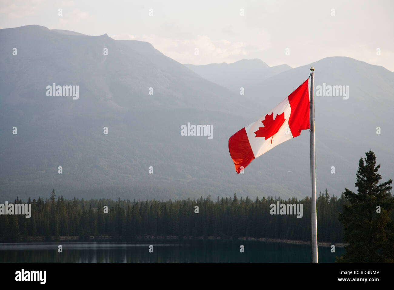 Canadian National Flag flying in Jasper National Park with the rockies behind Stock Photo