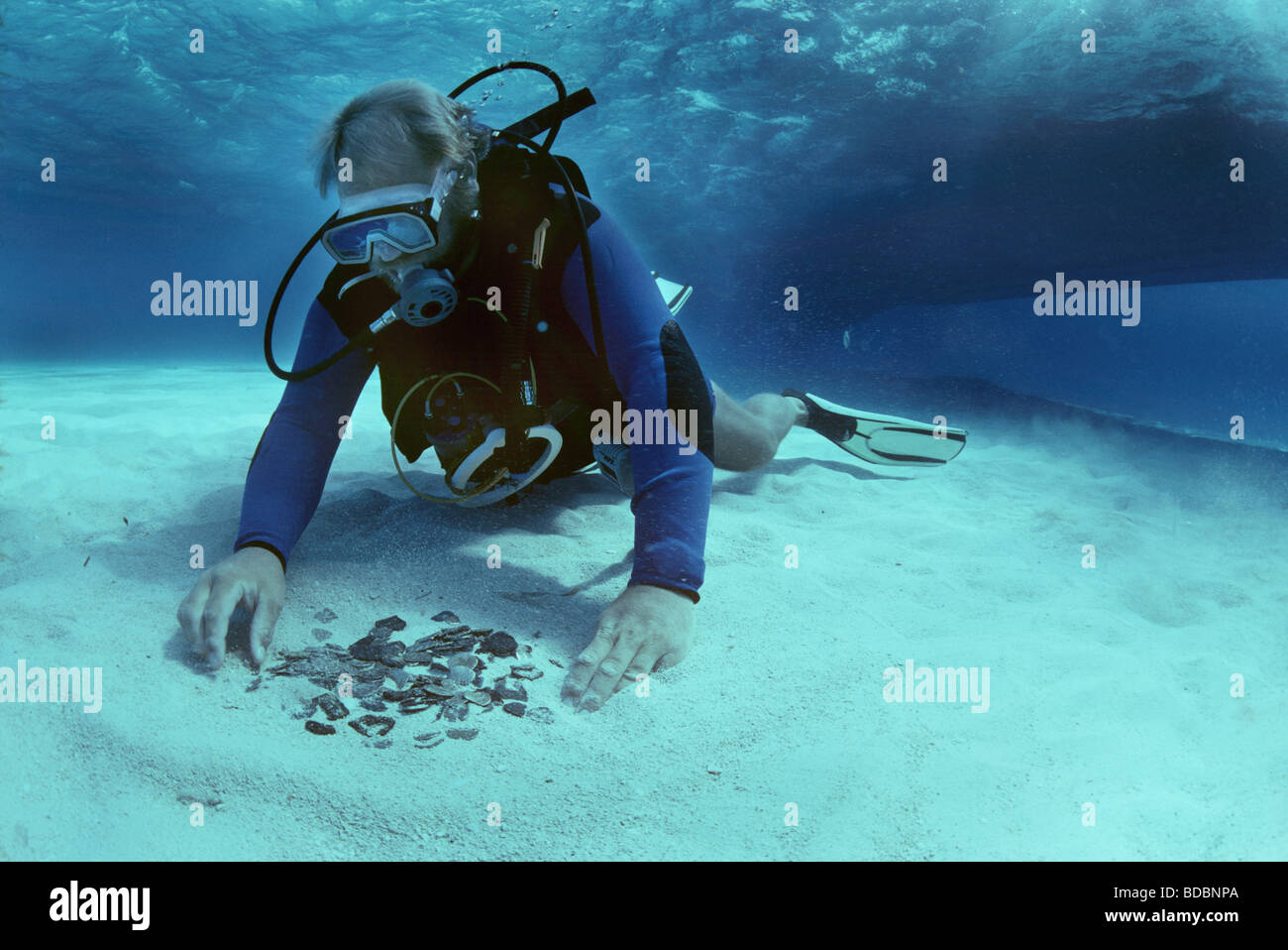 Diver recovers coins from the shipwreck Las Maravillas sunk in 1658 Bahamas  Stock Photo
