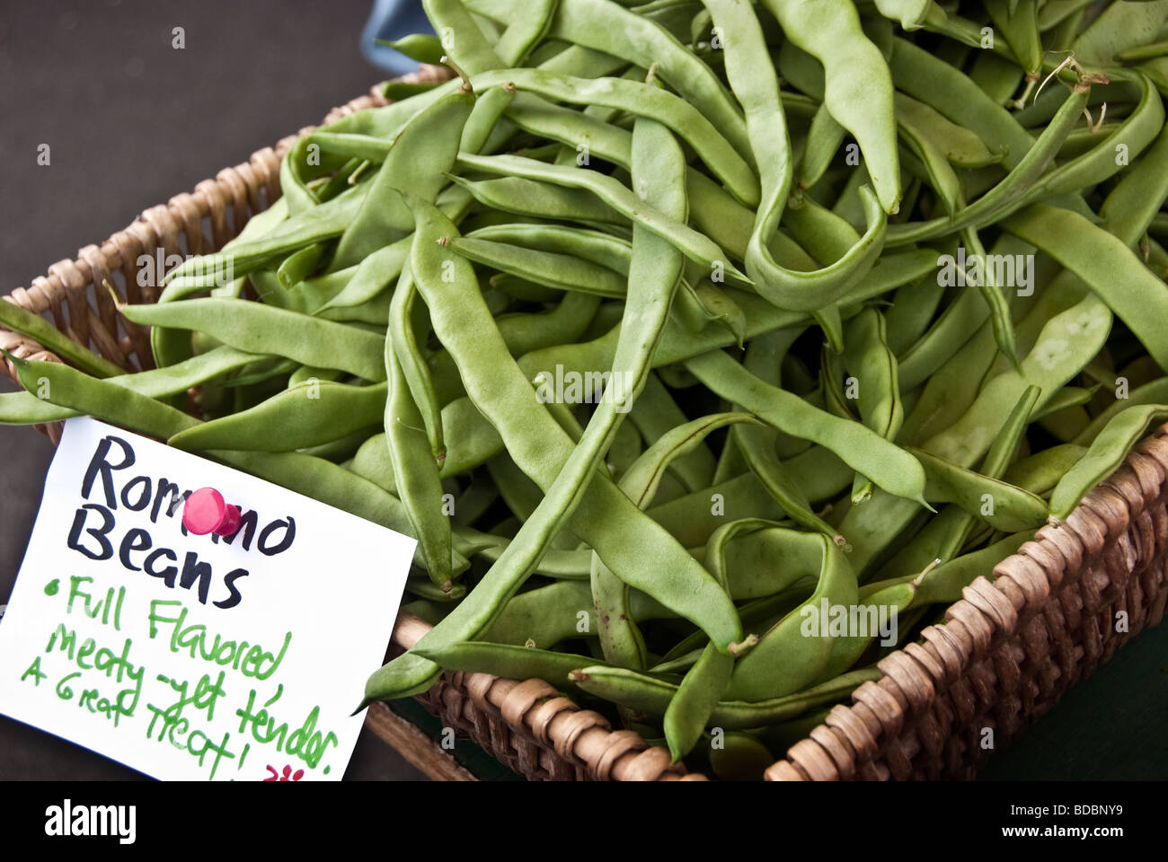a wicker pannier of fresh green Romano beans displayed for sale at the farmers green market Bellingham Washington Stock Photo