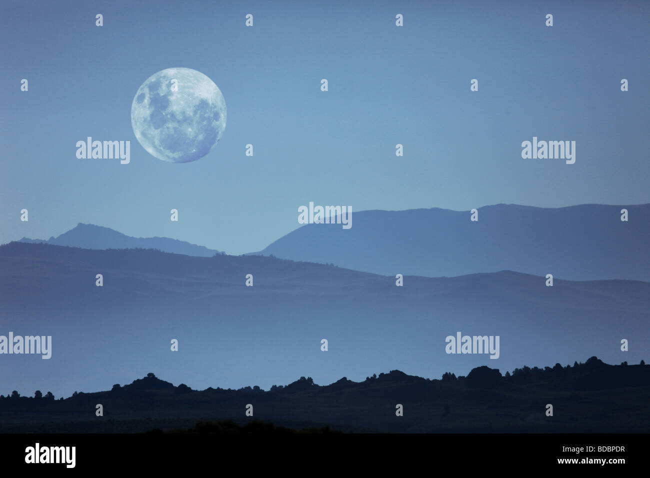 Beautiful Ghostly Mountain Silhouettes and Moon Moonscape Stock Photo