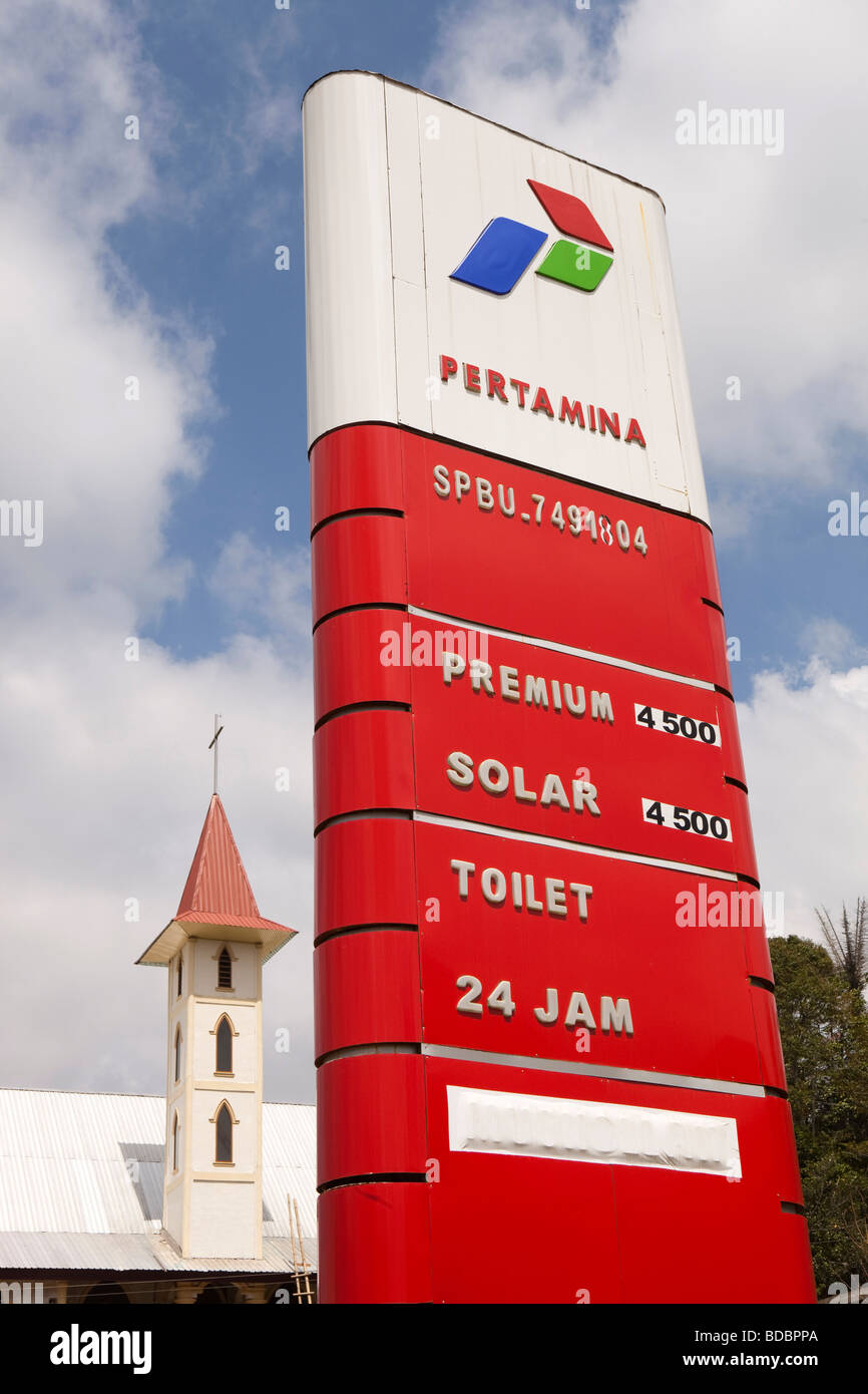 Indonesia Sulawesi Tana Toraja Makale Pertamina petrol station fuel prices sign beside church tower Stock Photo