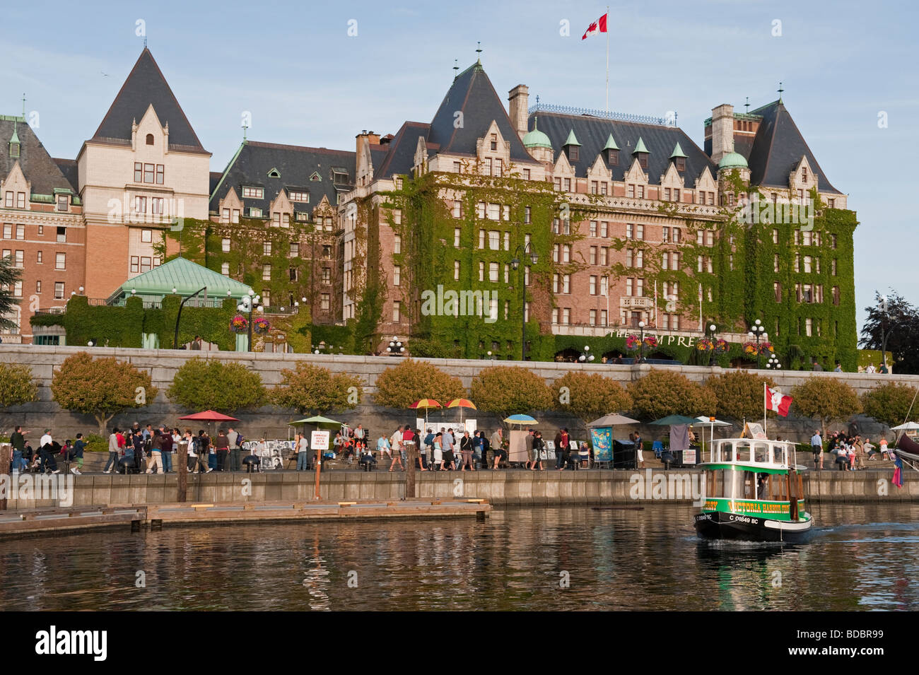 A water taxi ferries tourists around the inner harbor of Victoria, British Columbia, Canada. The Empress Hotel in the background Stock Photo